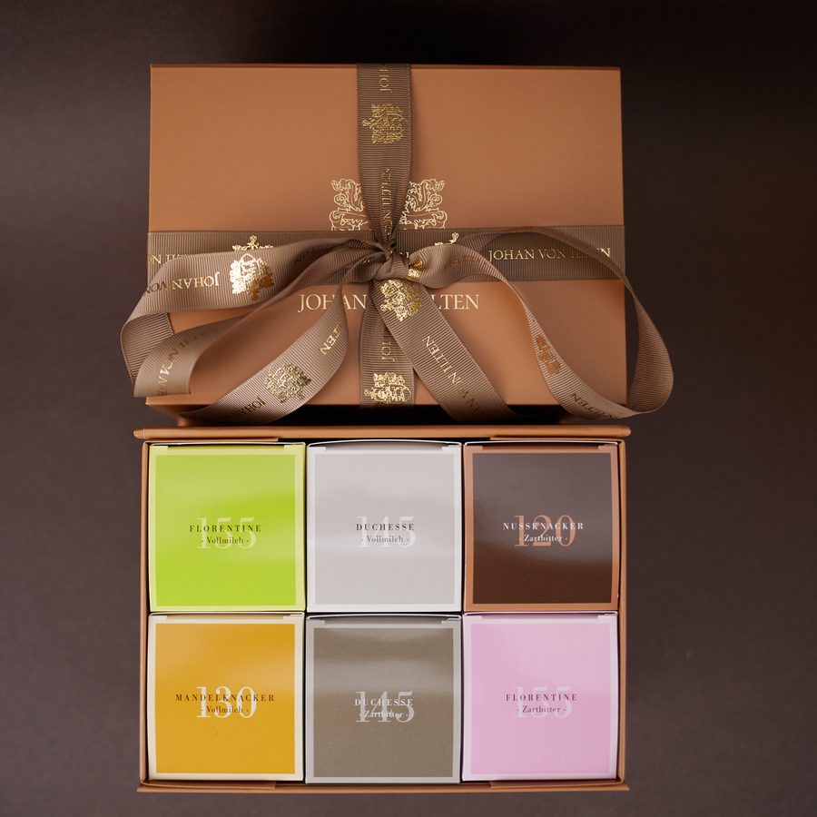 Die Genusskollektion: Geschenkbox mit geprägtem Schleifenband, darin sechs Gebäcksorten in farbigen Packungen